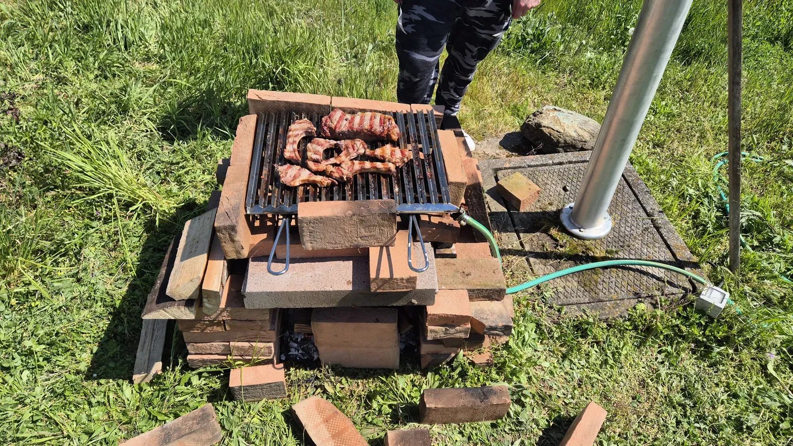 Una piccola griglia all’aperto con la carne in cottura