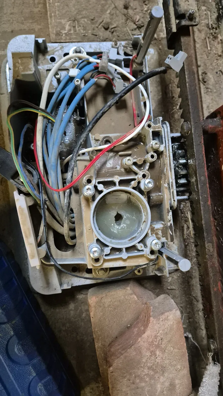 Il gruppo meccanico del portone aperto sul banco, con la carcassa metallica e i cavi a vista