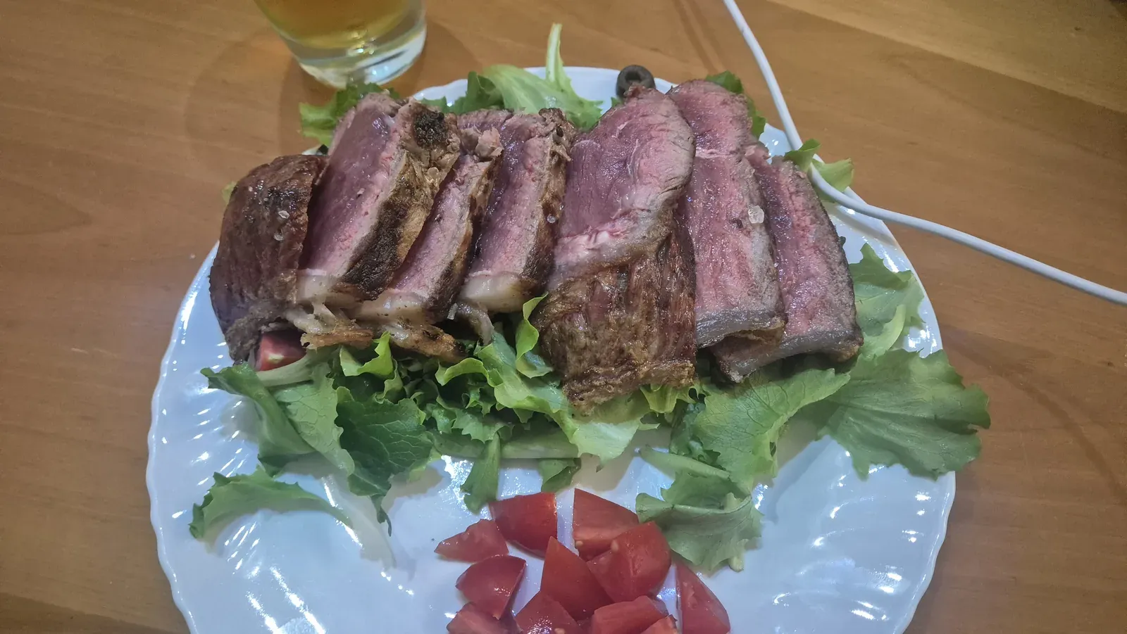 Fette di carne dall’interno rosato servite su un letto di foglie verdi