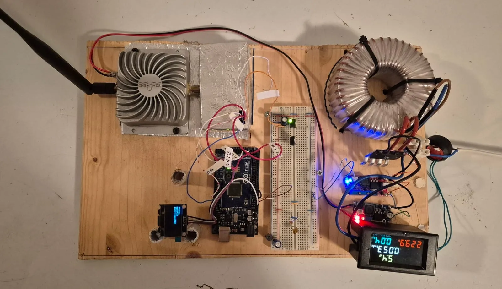 La tavola di prova con Arduino Mega, breadboard, display OLED, amplificatore RF con antenna, trasformatore toroidale e misuratore di potenza
