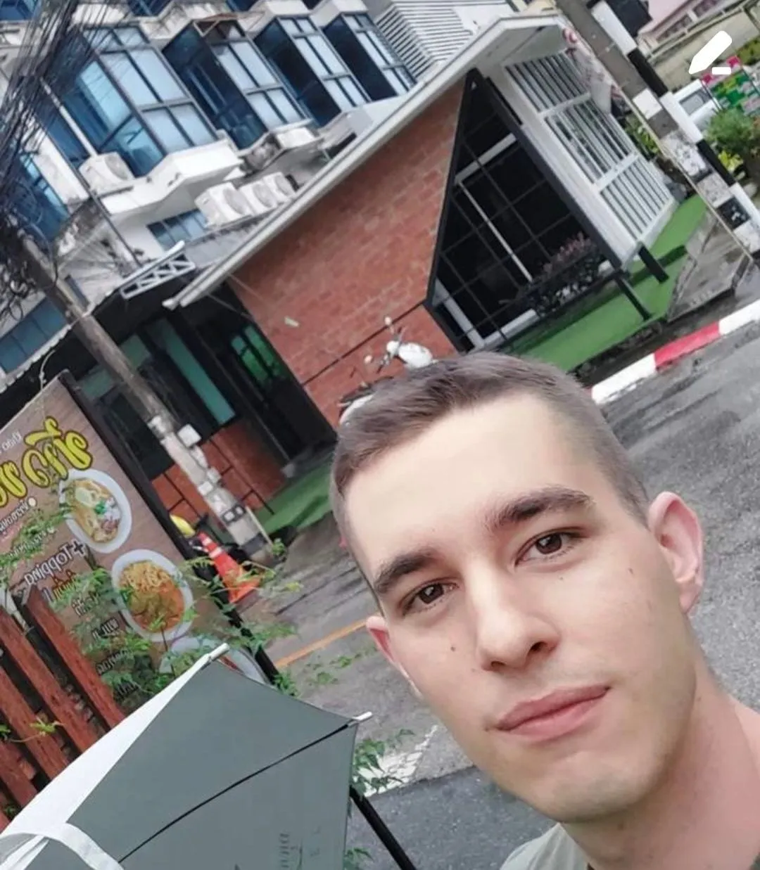 Un selfie di Gabriele per strada, con un ristorante sullo sfondo