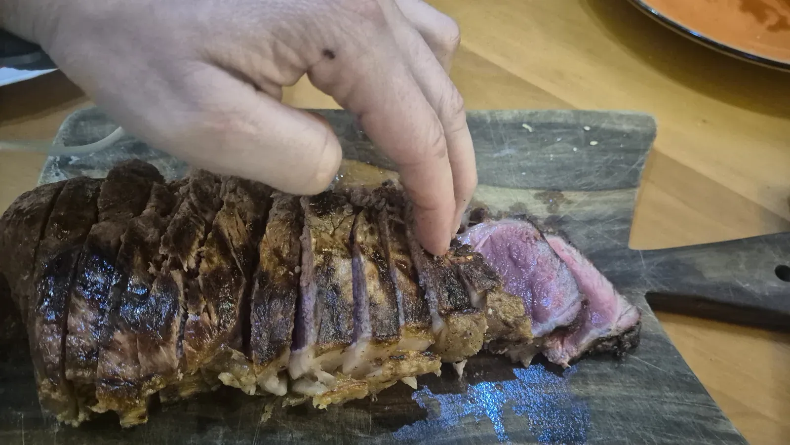Un pezzo di carne sul tagliere, tagliato a fette con l’interno rosato