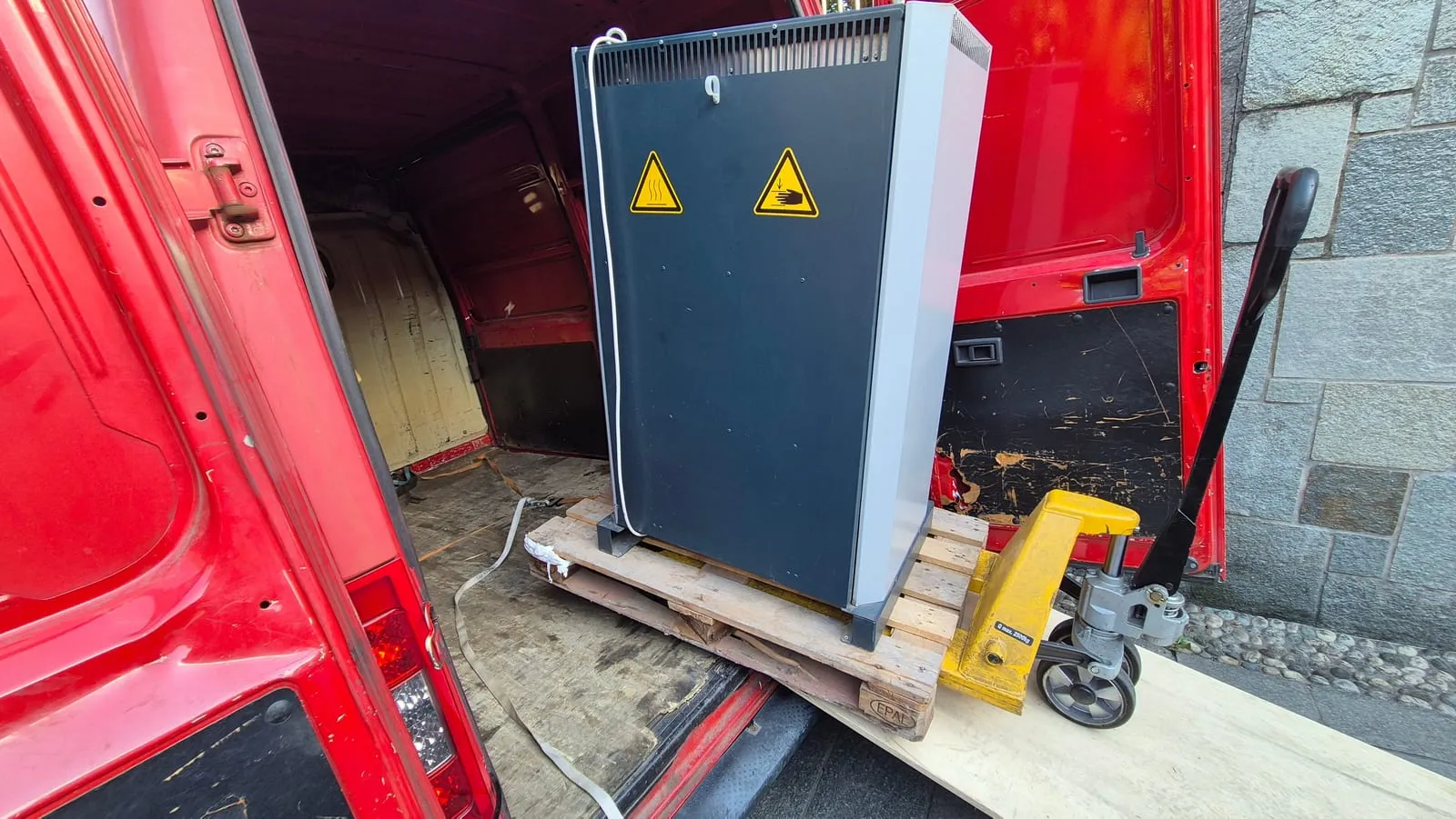 L’armadio KRC2 su pallet, nel vano di un furgone rosso, con il transpallet davanti